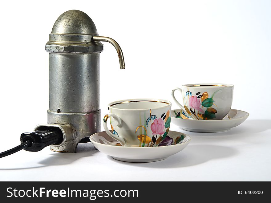 Old aluminium electrical  coffee machine  and two cups. Old aluminium electrical  coffee machine  and two cups