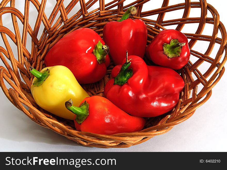 Red and yellow pepper in wooden basket