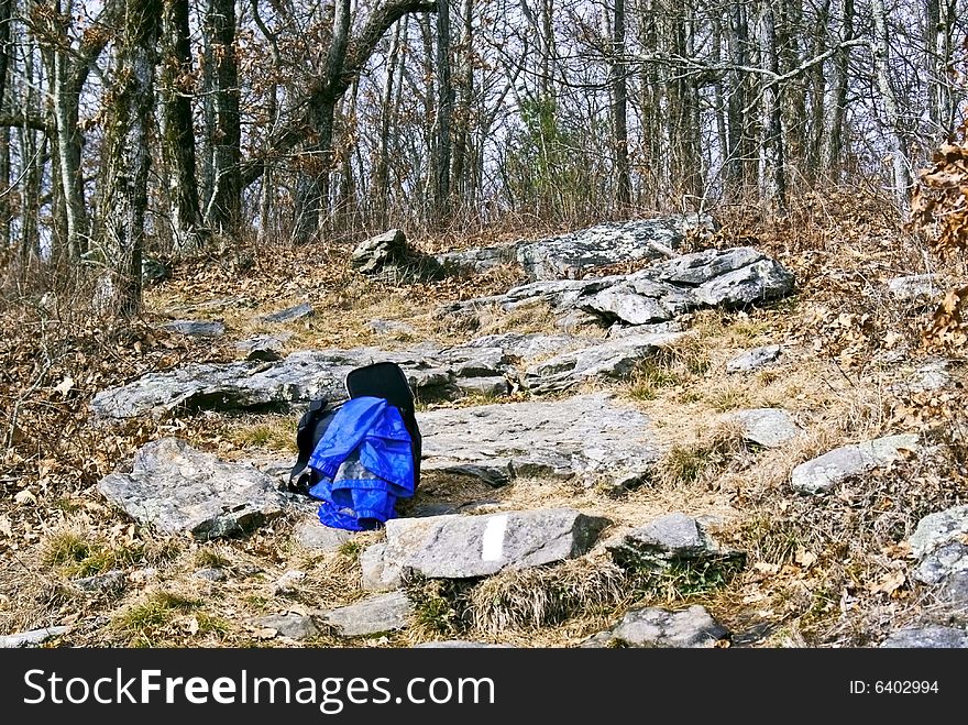 A backpack and jacket lying on the rocks of a trail. A backpack and jacket lying on the rocks of a trail.