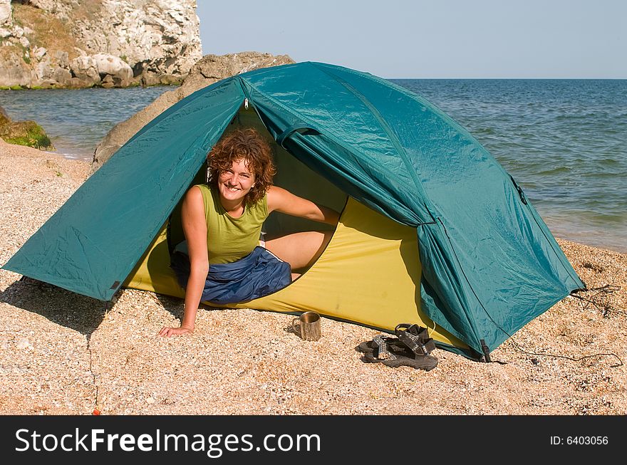 Smiling girl looking from a tent at seaside. Smiling girl looking from a tent at seaside