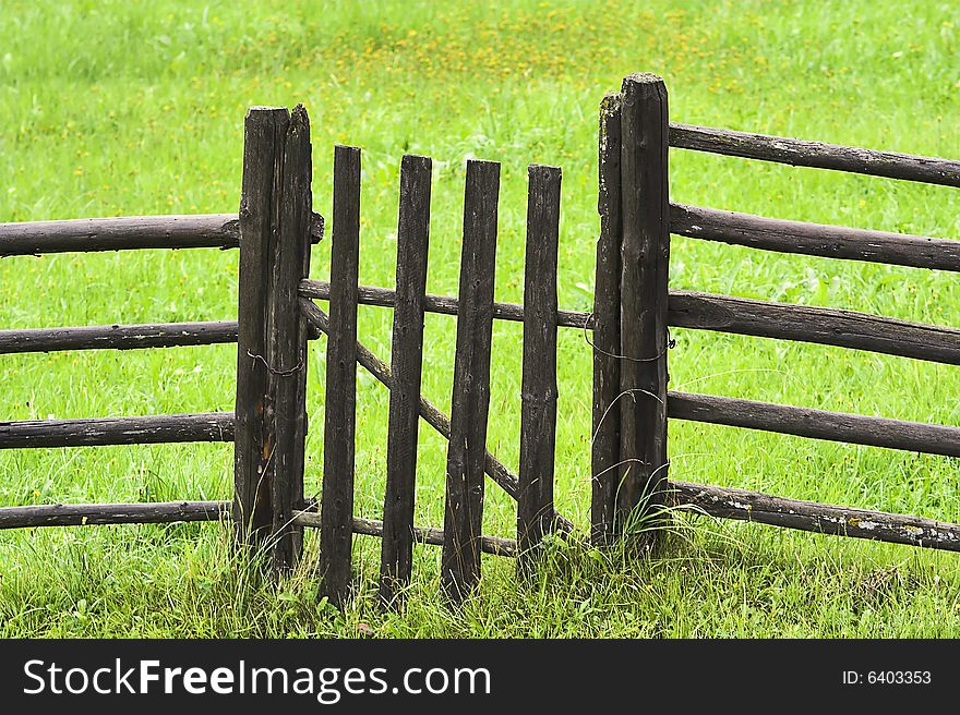 Rural fence against green grass lawn. Rural fence against green grass lawn