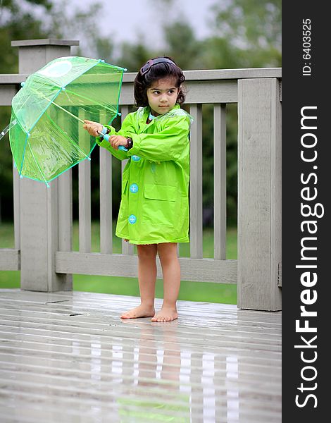 Young girl playing in the rain with rain gears. Young girl playing in the rain with rain gears
