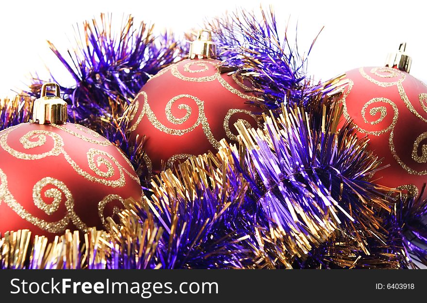Three red christmas balls decorated with tinsel isolated on white