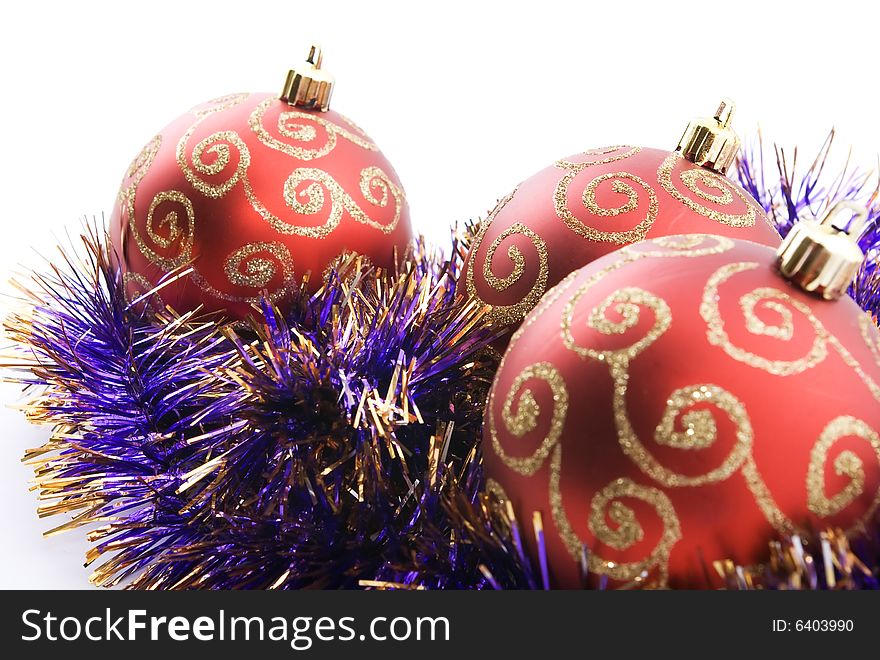 Three red christmas balls decorated with tinsel isolated on white