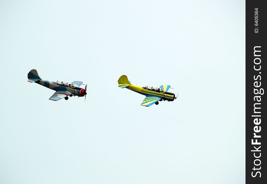 Two small propeller planes performing group aerobatics