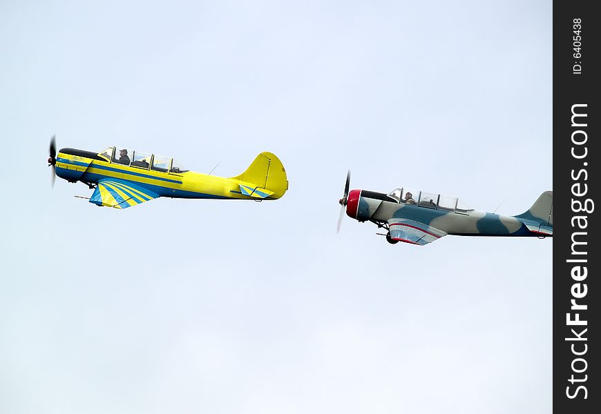 Two small propeller planes performing group aerobatics