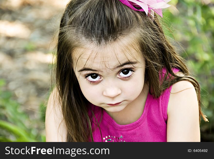 Beautiful brunette child with an expression on her face as if she's looking at you. Beautiful brunette child with an expression on her face as if she's looking at you.