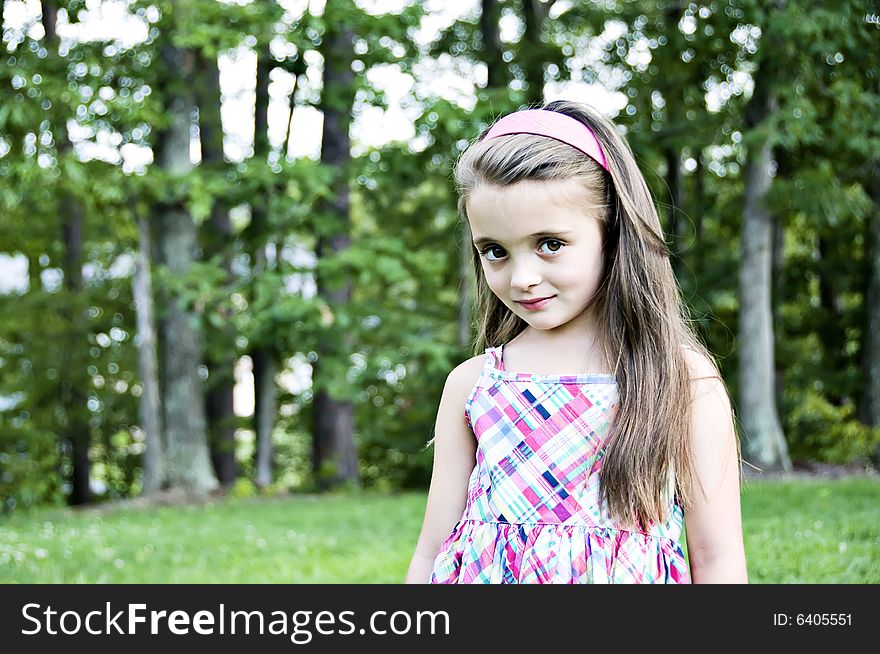 Closeup of a brunette, brown eyed girl with long hair and a pink headband. Closeup of a brunette, brown eyed girl with long hair and a pink headband.