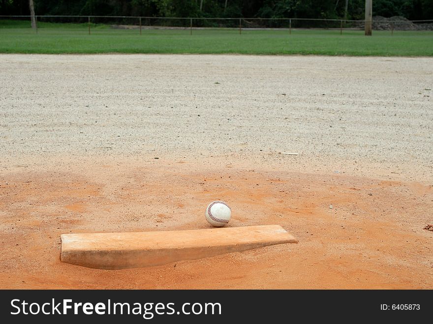 Single baseball on pitchers mound of empty field. Single baseball on pitchers mound of empty field.