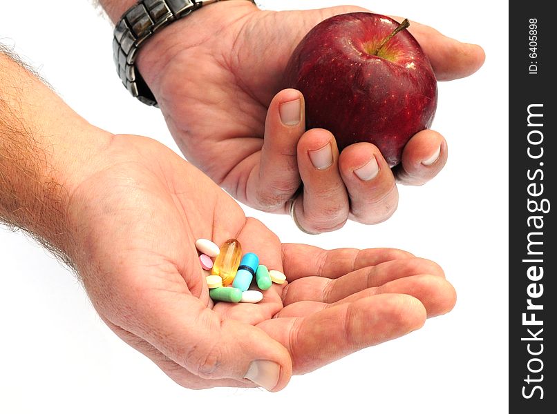 Shot of a hand holding some tablets and fruit. Shot of a hand holding some tablets and fruit