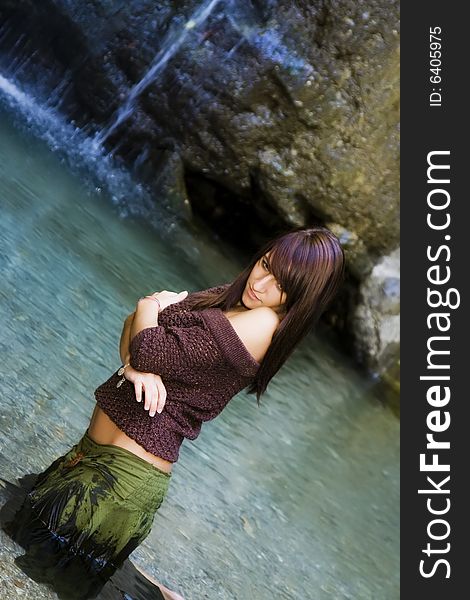 Young woman posing close to a waterfall. Young woman posing close to a waterfall