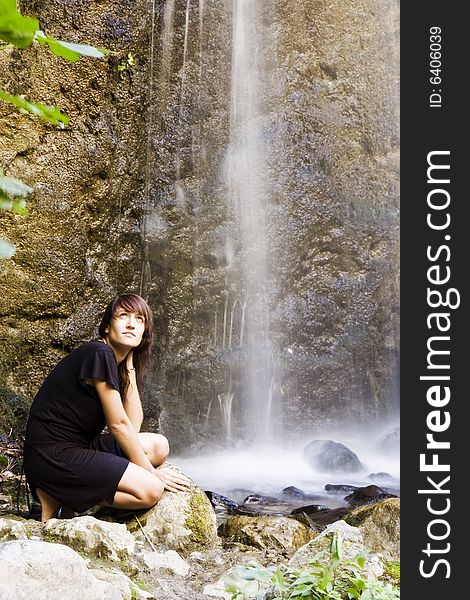 Young woman posing under long exposed waterfall. Young woman posing under long exposed waterfall