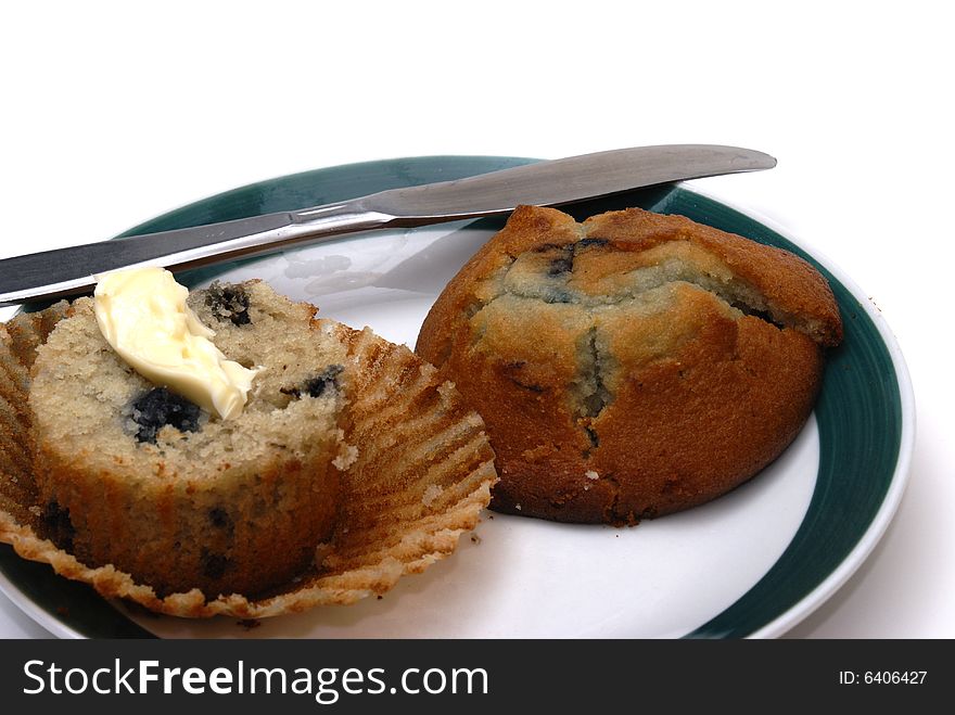 A freshly baked blueberry muffin with butter.