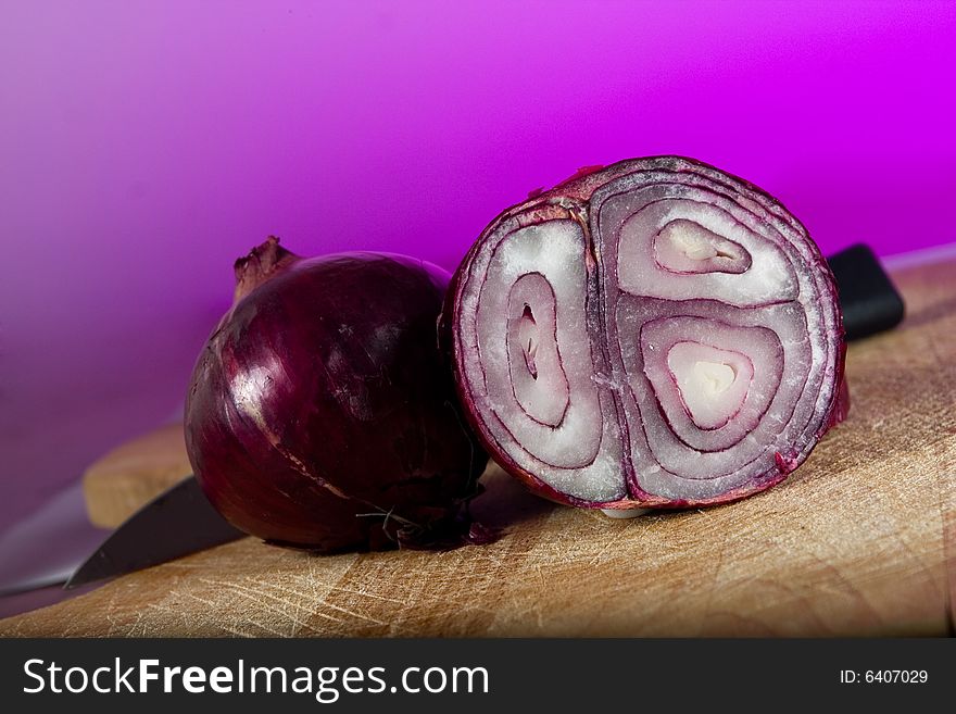 An onion a knife and a chopping board. An onion a knife and a chopping board