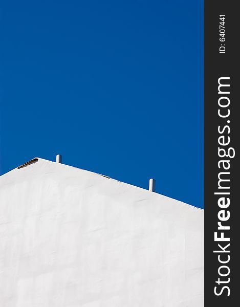 White vintage wall against the deep blue sky. White vintage wall against the deep blue sky