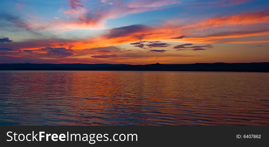 Sunset on the lake. Clouds, water and reflections. Great summer landscape.