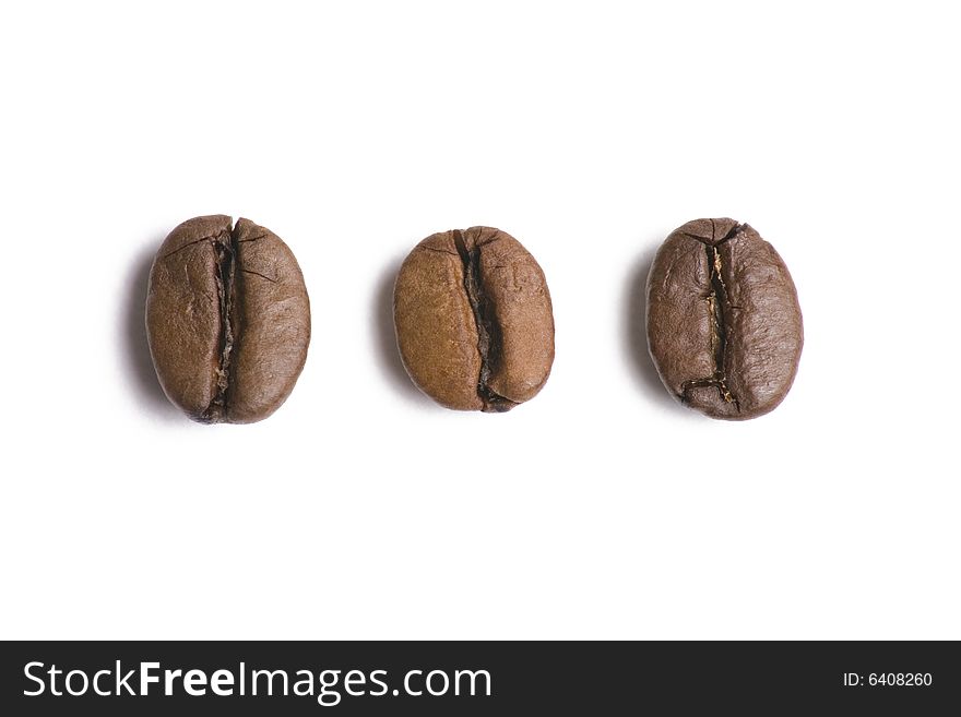 Three coffee beans in a row isolated on white background