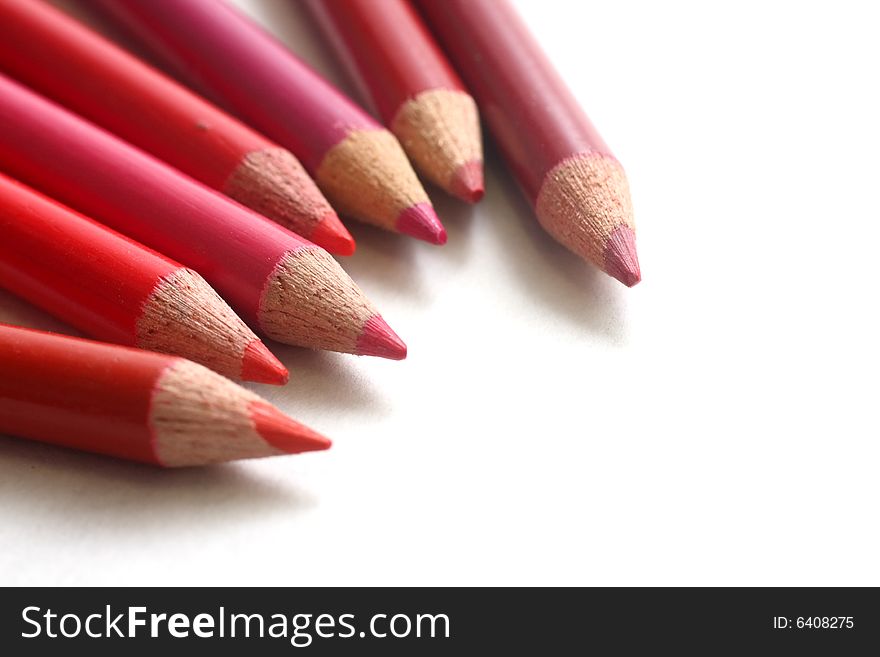 Different hues of red coloring pencils on white