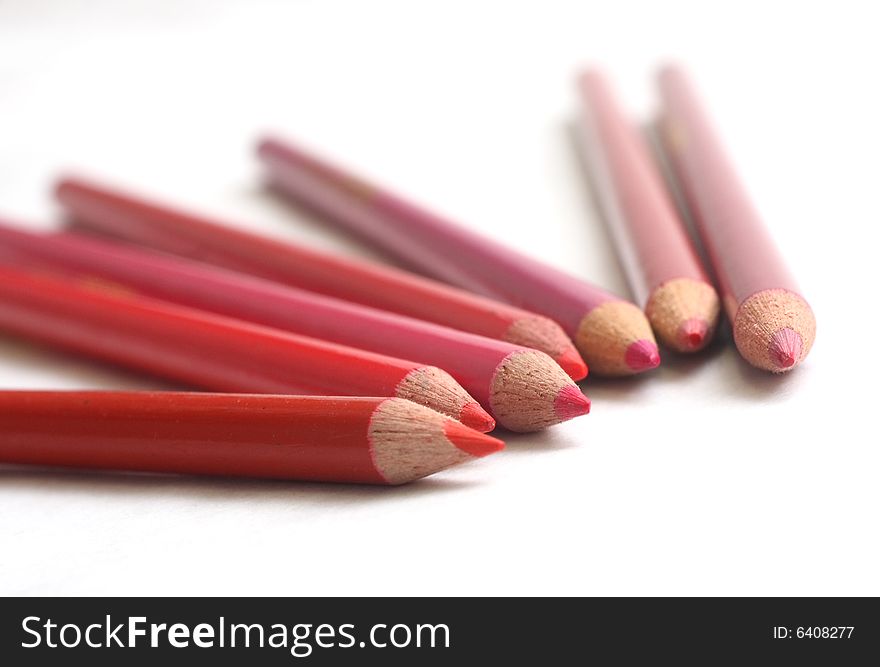 Different hues of red coloring pencils on white