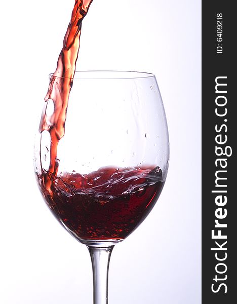 A stream of wine in a glass. A stream of wine in a glass