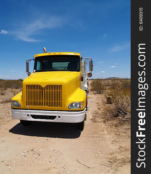 Photo of grille of yellow truck while working at a construction site. Vertically framed photo. Photo of grille of yellow truck while working at a construction site. Vertically framed photo.