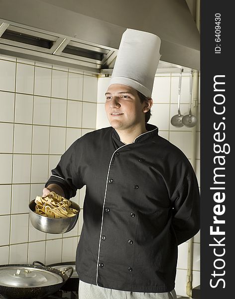 Smiling chef standing holding a bowl of noodles. Vertically framed photo. Smiling chef standing holding a bowl of noodles. Vertically framed photo.