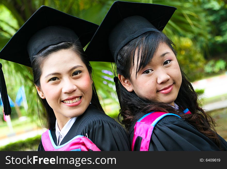 Gorgeous Asian university graduates celebrating their success.