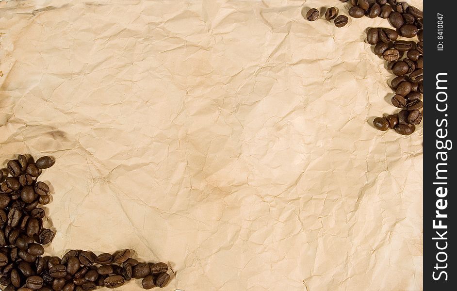 Coffee beans on old crumpled paper (as a frame or background)
