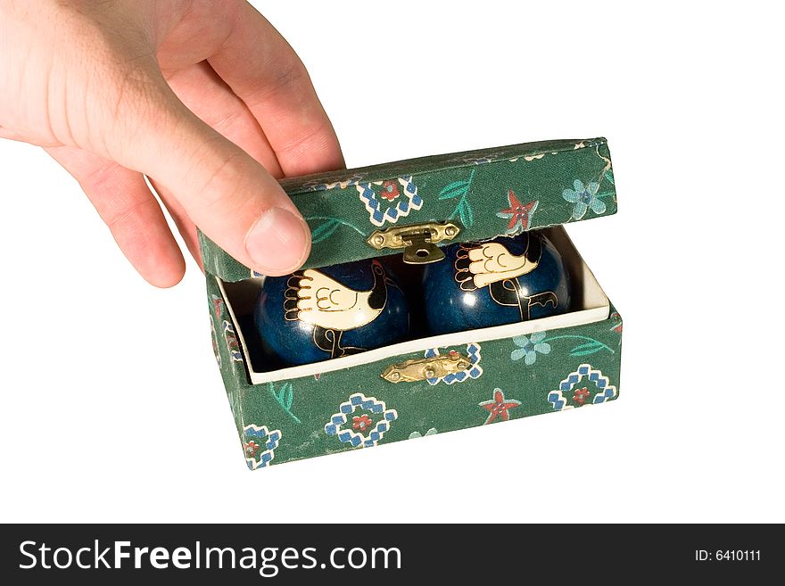 Man’s hand opening a box with antique Chinese relaxation balls (isolated on white). Man’s hand opening a box with antique Chinese relaxation balls (isolated on white)