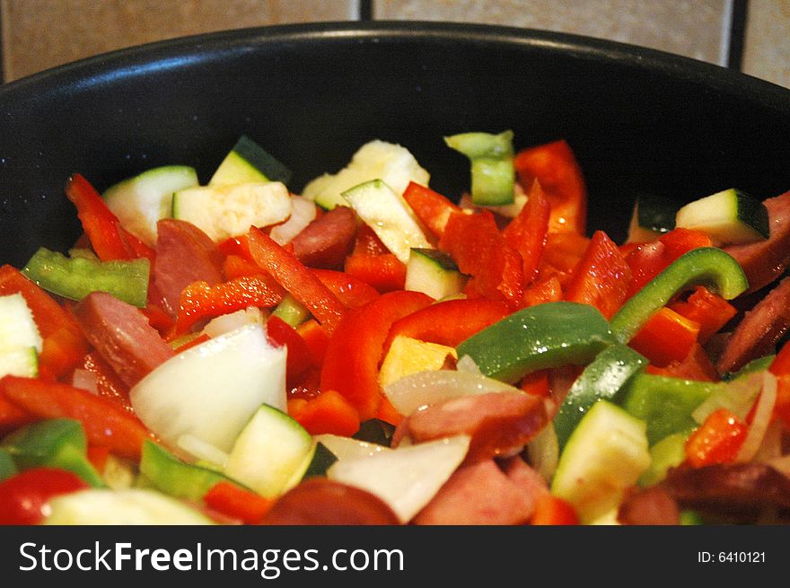 Mix of peppers, onion an sausage in a frying pan. Mix of peppers, onion an sausage in a frying pan