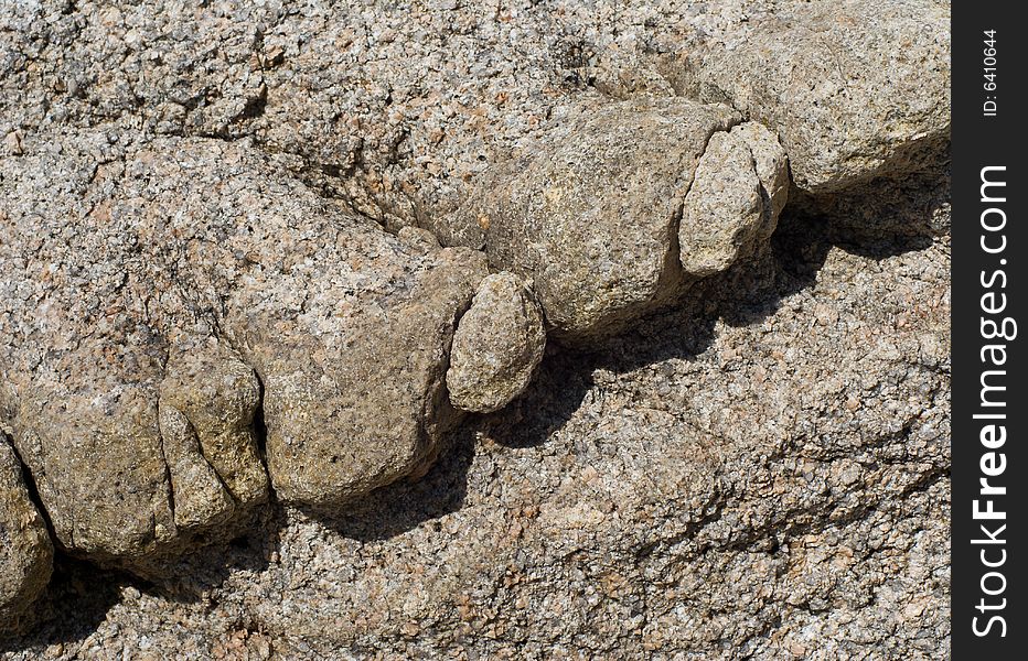 A close-up of a surface of very rough and granulated stone at seacoast. A close-up of a surface of very rough and granulated stone at seacoast.