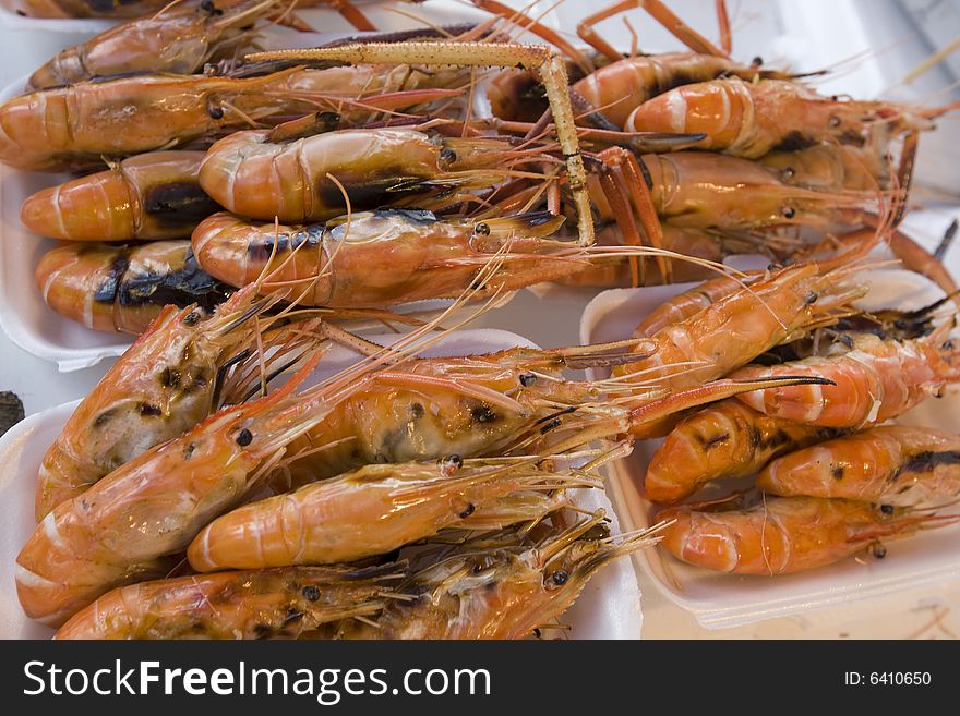 Prawns grilled on paper plate, on a market in Bangkok