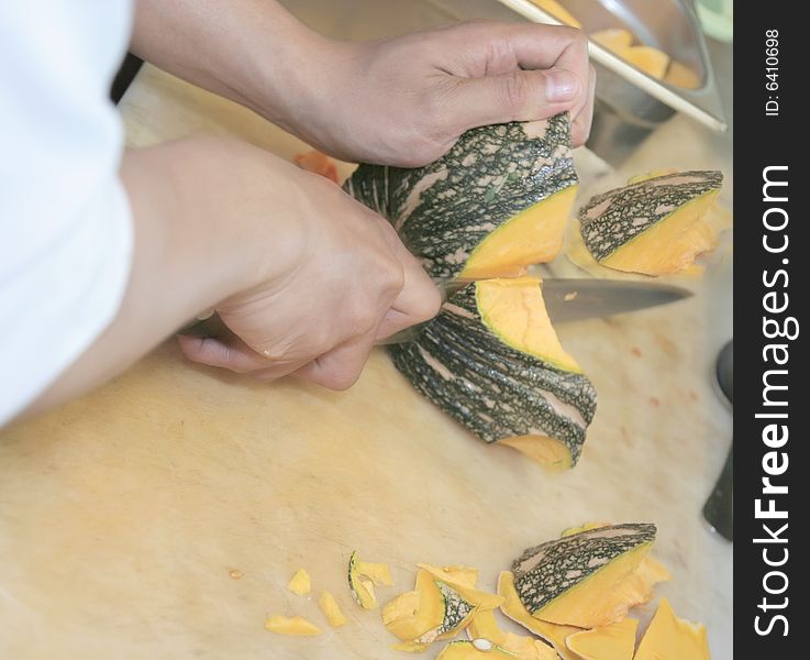 Chef cutting pumpkin fruit with knife
