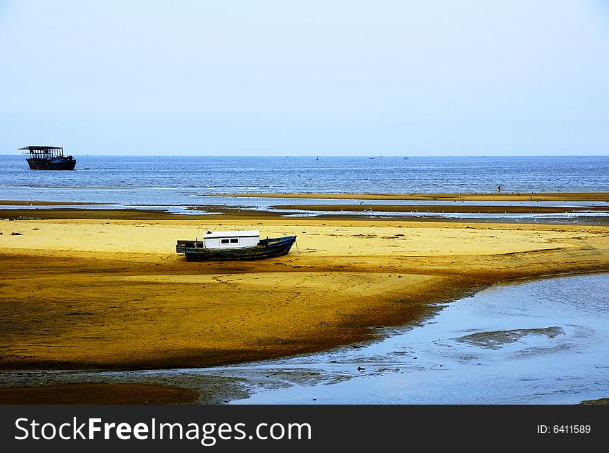 Small wooden boat in sand beach