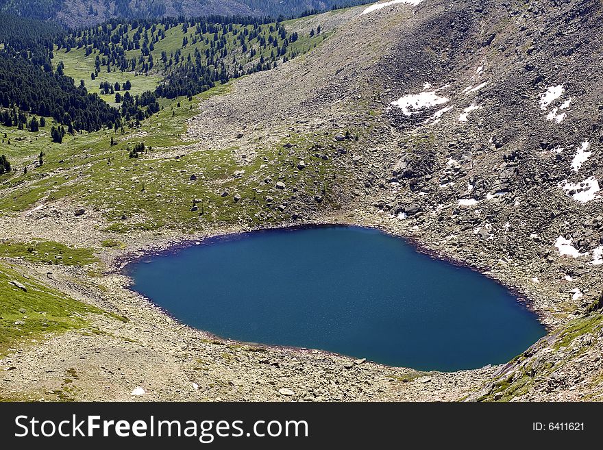 Lake in high mountains of Altai, summer, blue sky and white clouds
