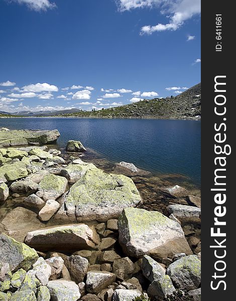 Lake in high mountains of Altai, summer, blue sky and white clouds