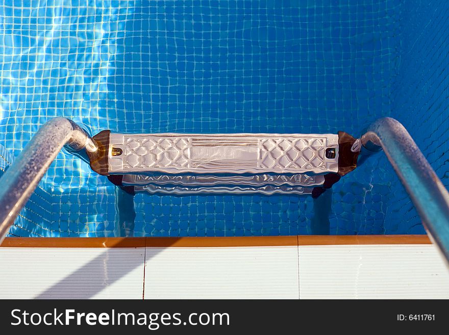 Swimming pool step with clear and blue water. Swimming pool step with clear and blue water