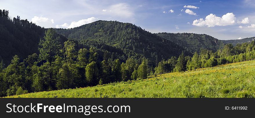 Panoramic picture in high mountains, summer, blue sky and white clouds