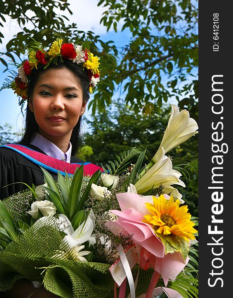 Beautiful young Asian graduate in robes on graduation day.