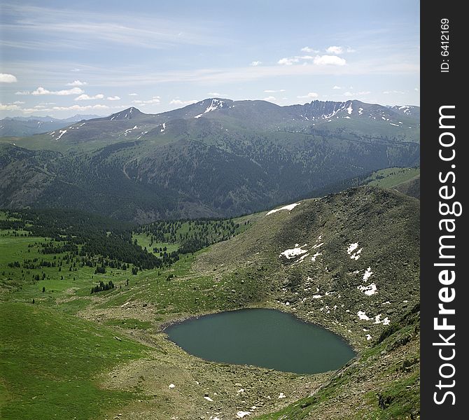 Lake in high mountains of Altai, summer, blue sky and white clouds