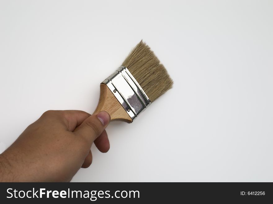 Hand holding  paintbrush over white background. Hand holding  paintbrush over white background
