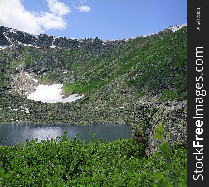 Lake in high mountains of Altai, summer, blue sky and white clouds