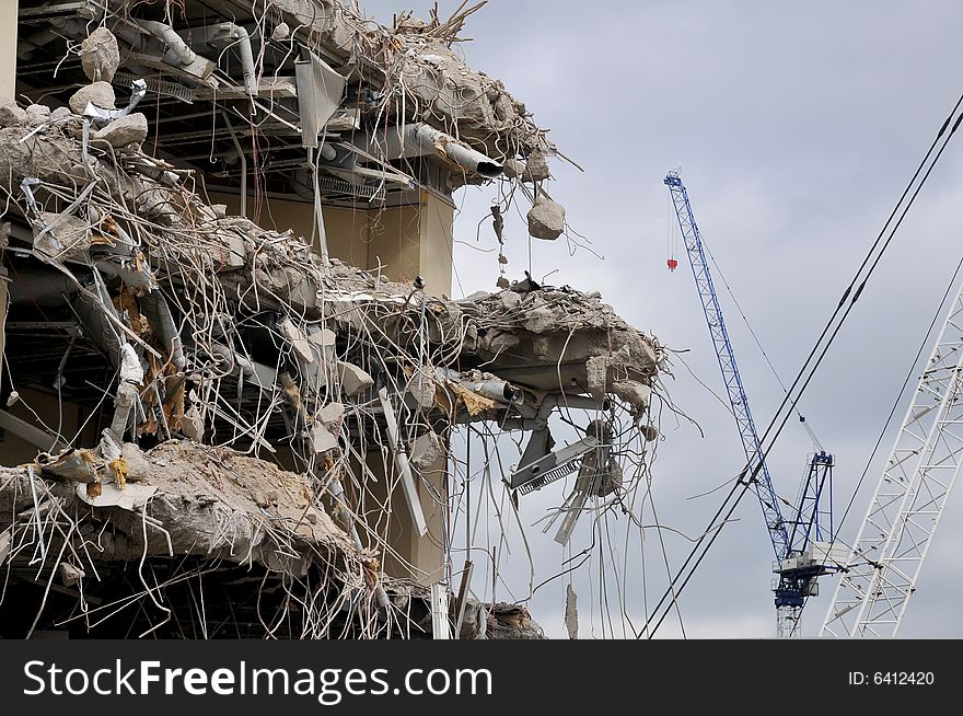 Building partially demolished with cranes, concrete and ducting exposed. Building partially demolished with cranes, concrete and ducting exposed