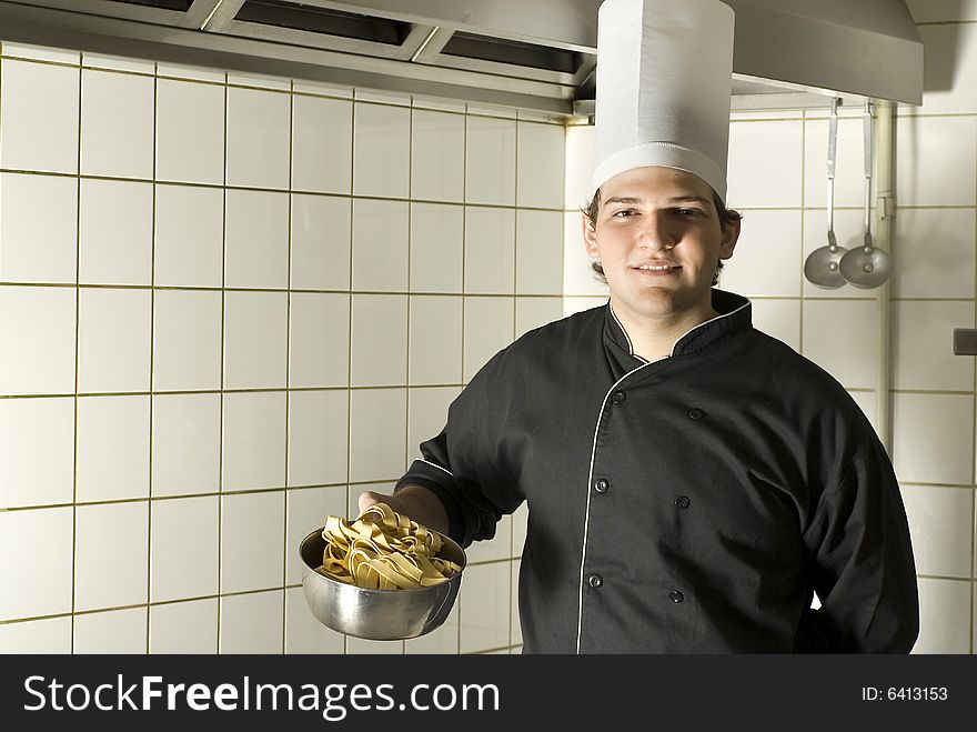 Smiling chef standing holding a bowl of noodles. Horizontally framed photo. Smiling chef standing holding a bowl of noodles. Horizontally framed photo.