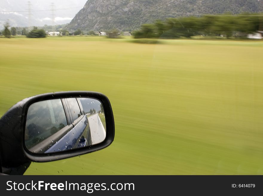 Side mirror of a car in motion. Side mirror of a car in motion