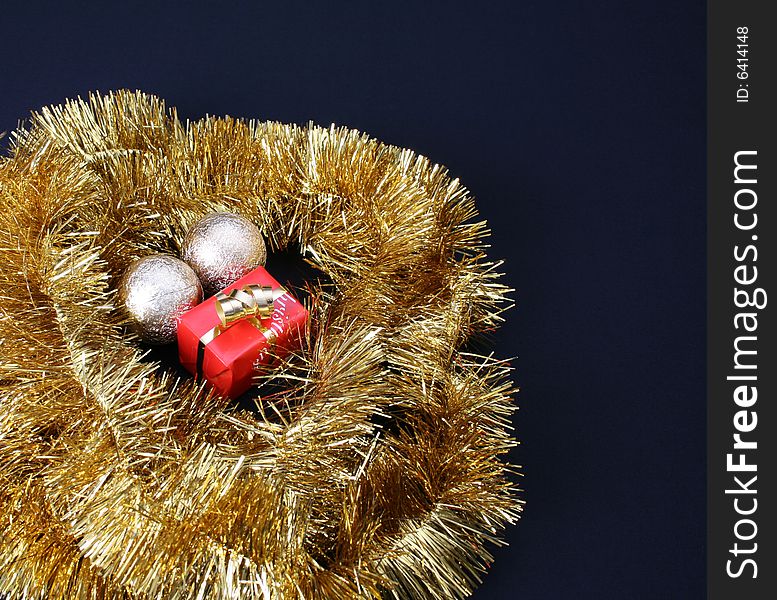 Small Christmas gift circled by gold tinsel string