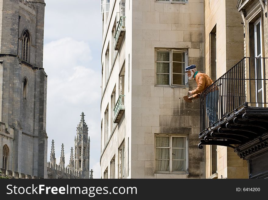 Monument: Old man feeding birds from the balcony. Monument: Old man feeding birds from the balcony