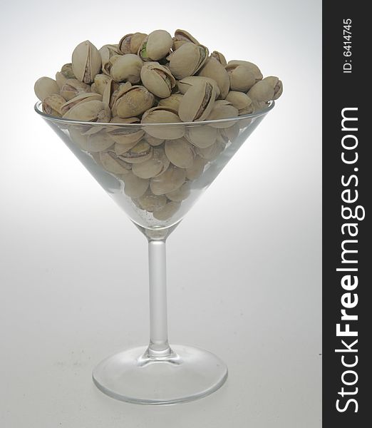 Pistachios in their shell, in a martini glass. Pistachios in their shell, in a martini glass