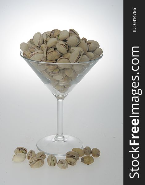 Pistachios in their shell, in a martini glass. Pistachios in their shell, in a martini glass