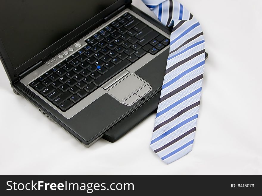 Laptop and tie on a white background